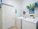 Bright laundry room with a washer, dryer, shelving, and tiled floors at 16631 Champions Ct, Clermont, FL 34711