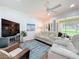 Comfortable living room featuring a plush white leather sofa and a view of the outdoors at 16631 Champions Ct, Clermont, FL 34711
