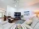 Bright living room with a white leather sofa, ceiling fan and beautiful accents at 16631 Champions Ct, Clermont, FL 34711