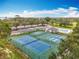 Community tennis and pickleball courts near a pool and parking area with mature landscaping at 16631 Champions Ct, Clermont, FL 34711