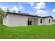 A lush green backyard extends from the home, complemented by a sliding glass door and modern design at 17485 Sw 41St Cir, Ocala, FL 34473