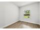 Bright bedroom with wood-look flooring and a large window offering views of the outdoors at 17485 Sw 41St Cir, Ocala, FL 34473