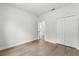 Bedroom features wood floors, closet, neutral colors, and an open doorway at 17485 Sw 41St Cir, Ocala, FL 34473