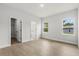 Spacious bedroom with wood-look floors, closet, and windows providing natural light at 17485 Sw 41St Cir, Ocala, FL 34473