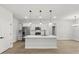 Bright kitchen with white cabinetry, large island with pendant lighting, and stainless steel appliances at 17485 Sw 41St Cir, Ocala, FL 34473
