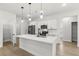 Modern kitchen with white cabinets, center island with quartz countertop, stainless steel appliances and stylish fixtures at 17485 Sw 41St Cir, Ocala, FL 34473