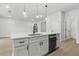 Kitchen island with a sink, dishwasher, white cabinets and a view into the adjacent living area at 17485 Sw 41St Cir, Ocala, FL 34473