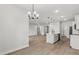 Bright open-concept kitchen with white cabinets, center island, and stainless-steel appliances adjacent to the dining area at 17485 Sw 41St Cir, Ocala, FL 34473