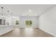 Open-concept living room features modern lighting, wood-look flooring and sliding glass doors to the backyard at 17485 Sw 41St Cir, Ocala, FL 34473