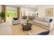 Bright living room showcasing neutral tones, large windows, and open floor plan to kitchen and dining area at 17485 Sw 41St Cir, Ocala, FL 34473