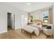 Comfortable bedroom with a large bed, chair, bench and two windows providing natural light at 17485 Sw 41St Cir, Ocala, FL 34473