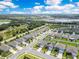 Scenic aerial view of a residential neighborhood with homes, streets, trees, and a picturesque lake in the distance at 1854 Juneberry St, Clermont, FL 34715
