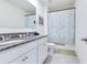 Bathroom with double granite vanity, framed mirror, and a shower/tub combo with patterned curtain at 1854 Juneberry St, Clermont, FL 34715