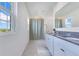 Bathroom featuring double sinks, stone countertops, and walk-in shower at 1854 Juneberry St, Clermont, FL 34715