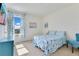 Light-filled bedroom featuring soft blue bedding and curtains, and a mounted television set at 1854 Juneberry St, Clermont, FL 34715