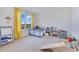 Bright bedroom featuring a window, grey playpen, easel, and open shelving for toys at 1854 Juneberry St, Clermont, FL 34715