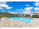 Gorgeous community pool with lounge chairs surrounded by houses and blue skies at 1854 Juneberry St, Clermont, FL 34715