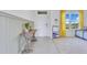Inviting foyer with wood-look console table, wainscotting detail, and bright window with yellow curtains at 1854 Juneberry St, Clermont, FL 34715
