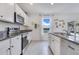 Well-lit kitchen with stainless steel appliances and granite countertops, ideal for cooking at 1854 Juneberry St, Clermont, FL 34715