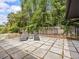 Charming backyard patio features gray geometric pavers, lounge chairs, and verdant foliage at 2244 Brookshire Ave, Winter Park, FL 32792