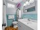 Well-lit bathroom featuring an updated sink, cabinet, turquoise tiling, and decorative purple flowers at 2244 Brookshire Ave, Winter Park, FL 32792