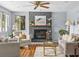 Cozy living room with fireplace, hardwood floors, and natural light from large windows at 2244 Brookshire Ave, Winter Park, FL 32792