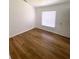 Bedroom with wood-look flooring, white walls, and a large window with blinds for natural light at 2524 Daffadil Ter, Sanford, FL 32771