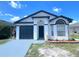 Exterior elevation of a single-story home with a dark roof, dark garage door, and a manicured lawn at 2524 Daffadil Ter, Sanford, FL 32771