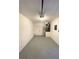 Spacious garage with epoxy flooring and storage shelves; features a water heater, lighting, and electrical panel at 2524 Daffadil Ter, Sanford, FL 32771