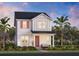 Charming two-story home with white siding, red shutters, and landscaped yard at 2623 Long Pine Ave, Apopka, FL 32712
