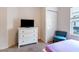 Bedroom featuring a television on a dresser, closet, chair, and a window at 2901 Edenshire Way # 102, Kissimmee, FL 34746