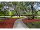 Serene park featuring lush greenery, a walking path, and benches for relaxing by the water at 2901 Edenshire Way # 102, Kissimmee, FL 34746