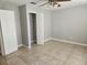 Bedroom features tile flooring, neutral walls, and a large closet with shelving for storage at 304 Lake Daisy Loop, Winter Haven, FL 33884