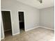 Bedroom showcases tile flooring, neutral walls, and two open doors for closets and bathroom access at 304 Lake Daisy Loop, Winter Haven, FL 33884