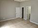Bedroom features tile flooring, neutral walls, and 3 doors, for access to closets and bathroom at 304 Lake Daisy Loop, Winter Haven, FL 33884