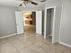 Neutral bedroom features a ceiling fan, closet, and doorway to the kitchen at 304 Lake Daisy Loop, Winter Haven, FL 33884