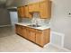 Well-lit kitchen featuring light wood cabinets, marble countertops, and tile flooring at 304 Lake Daisy Loop, Winter Haven, FL 33884