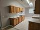 Modern kitchen with light wood cabinets, marble countertops, stainless steel sink, and tile floor at 304 Lake Daisy Loop, Winter Haven, FL 33884