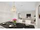 Elegant dining area with modern lighting and a view into the bright living room at 307 Monterey St, Kissimmee, FL 34759