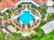 Aerial view of a resort-style pool with palm trees, lounge chairs, and meticulously landscaped grounds at 307 Monterey St, Kissimmee, FL 34759