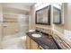 Neutral bathroom featuring a glass shower, granite counters, framed mirror and updated fixtures at 344 Blue Bayou Dr, Kissimmee, FL 34743