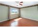 Bedroom with hardwood floors, ceiling fan, and a window overlooking a tranquil pond at 344 Blue Bayou Dr, Kissimmee, FL 34743
