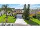 Two-story home with a well-manicured lawn, mature landscaping, and a long driveway at 344 Blue Bayou Dr, Kissimmee, FL 34743
