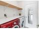 Laundry room with modern washer and dryer, counter space, and storage shelves at 344 Blue Bayou Dr, Kissimmee, FL 34743