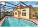 Back of home with a screened-in pool, tile patio and access to the backyard at 344 Blue Bayou Dr, Kissimmee, FL 34743