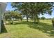 A well-maintained backyard with a lush lawn, mature trees, and a wrought iron fence at 36646 Oconee Ave, Eustis, FL 32736