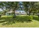 A well-manicured lawn with mature trees shading the backyard of a charming house at 36646 Oconee Ave, Eustis, FL 32736
