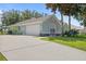 View of house showing long driveway, two car garage, well manicured lawn and view of back yard at 36646 Oconee Ave, Eustis, FL 32736