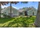 Charming one-story home featuring a lush green lawn and inviting curb appeal with stone accents and mature trees at 36646 Oconee Ave, Eustis, FL 32736