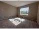 Cozy bedroom with natural light streaming through the window and neutral carpeting at 3950 Alba Dr, Indian Lake Estates, FL 33855